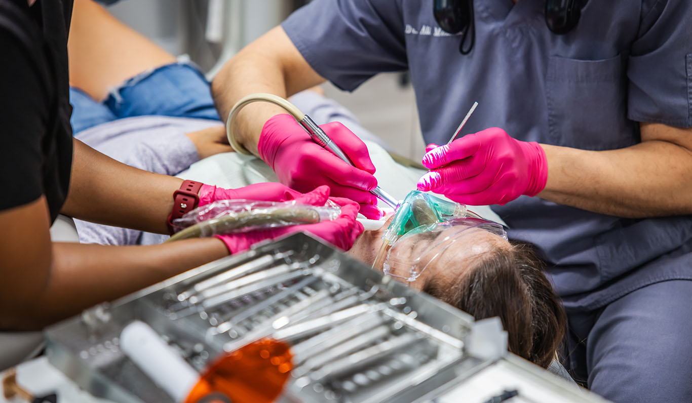 a woman is cutting a woman's hair with scissors  at pediatric dentistry Reston in Reston, VA